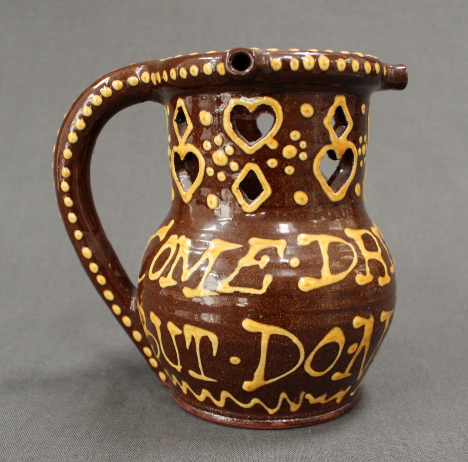 A glazed terracotta puzzle jug
